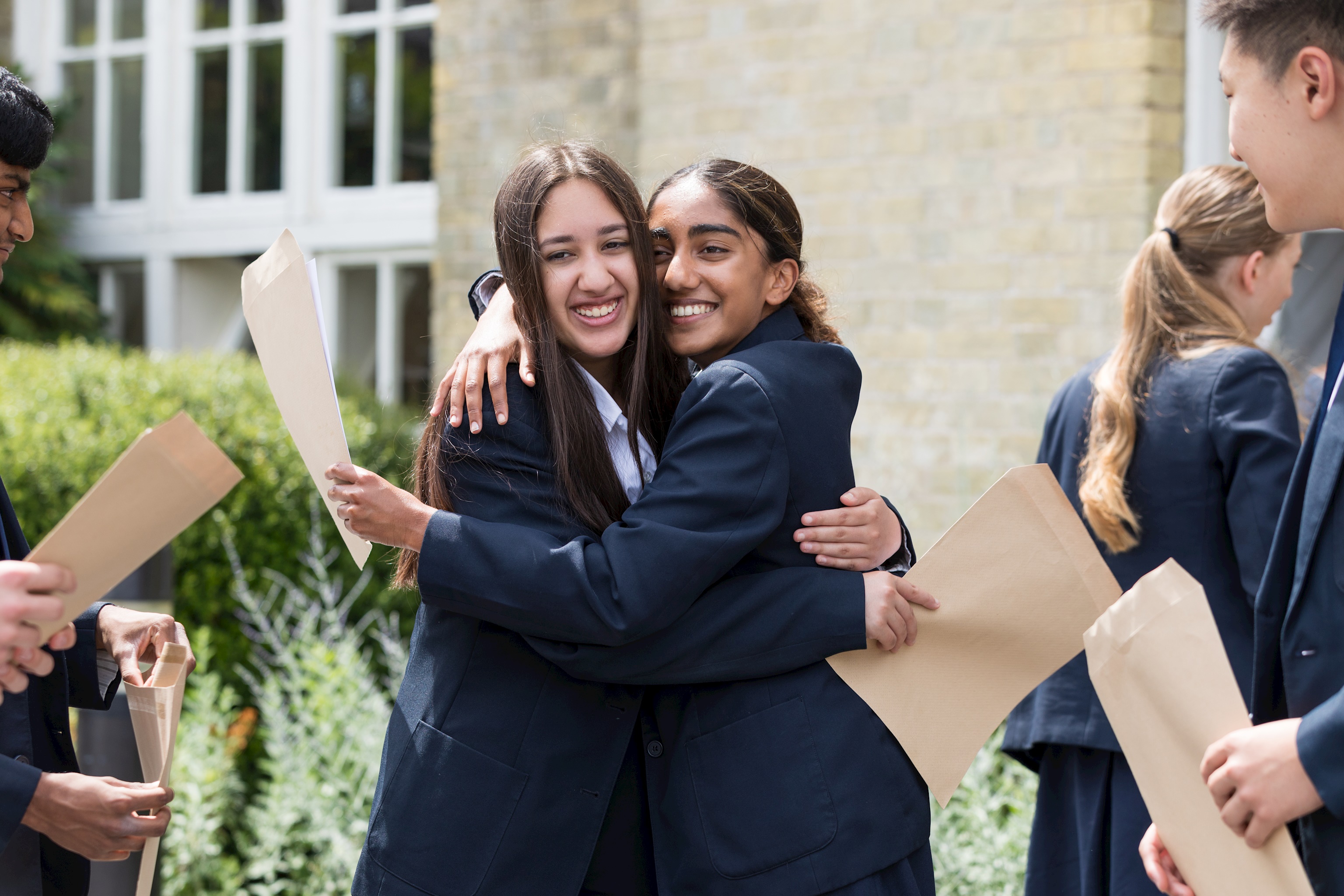 GCSE students hug as they receive their excellent results at Freemen's